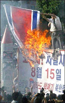 15일 서울 시청 앞 광장에서 열린 `건국 55주년 반핵반김 8.15 국민대회`에서 한 참가자가 인공기를 불태우고 있다. 